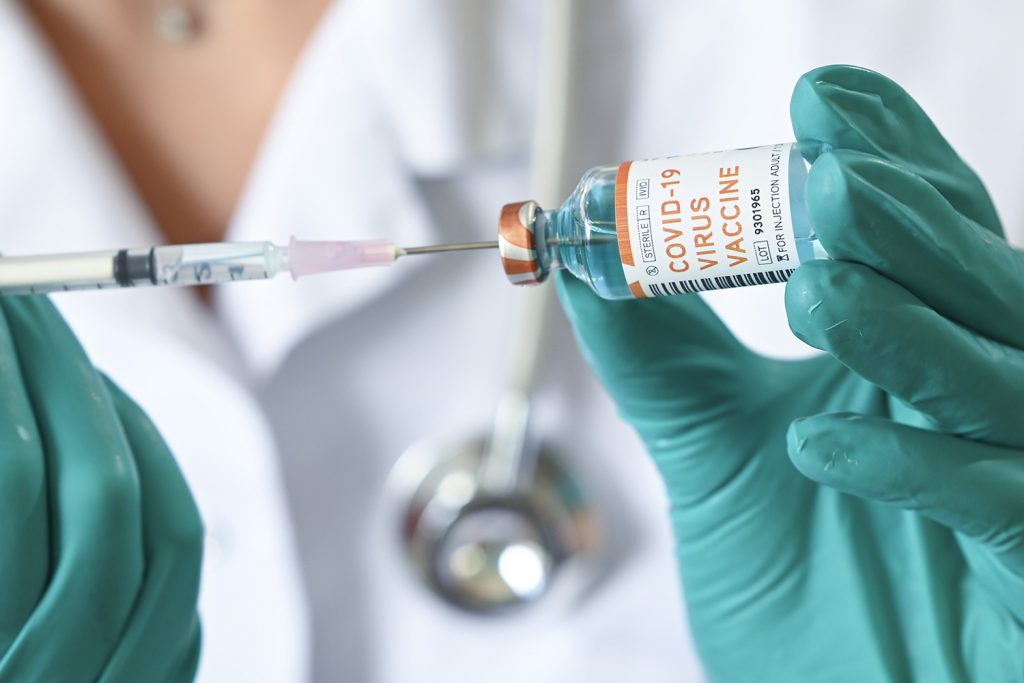 BRUSSELS, BELGIUM - JUNE 18 : In this illustration a doctor holds a syringe and a bottle labelled as the Covid-19 coronavirus vaccine. At least 8,000,202 cases of infection, including 435,176 deaths, were recorded in total, particularly in Europe, the continent most affected with 2,417,902 cases (188,085 deaths) and in the United States, which has the highest number of cases (2,110,182) and deaths (116,081). There are about a hundred projects for vaccines against Covid-19, of which about ten are in the clinical trial phase. Pictured on June 18, 2020 in Brussels, Belgium, 18/06/2020 ( Photo by Vincent Kalut / Photonews via Getty Images)